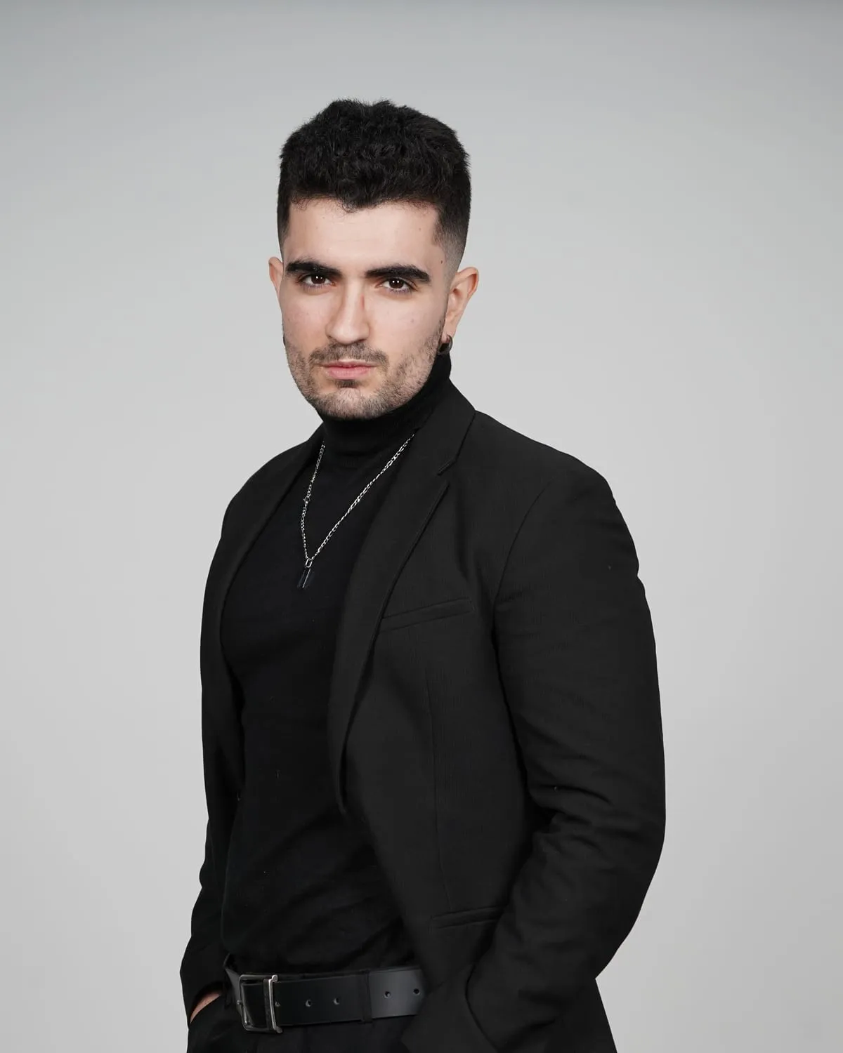 Retrato de Jairo Jiménez Pruñanosa con traje negro sobre fondo gris